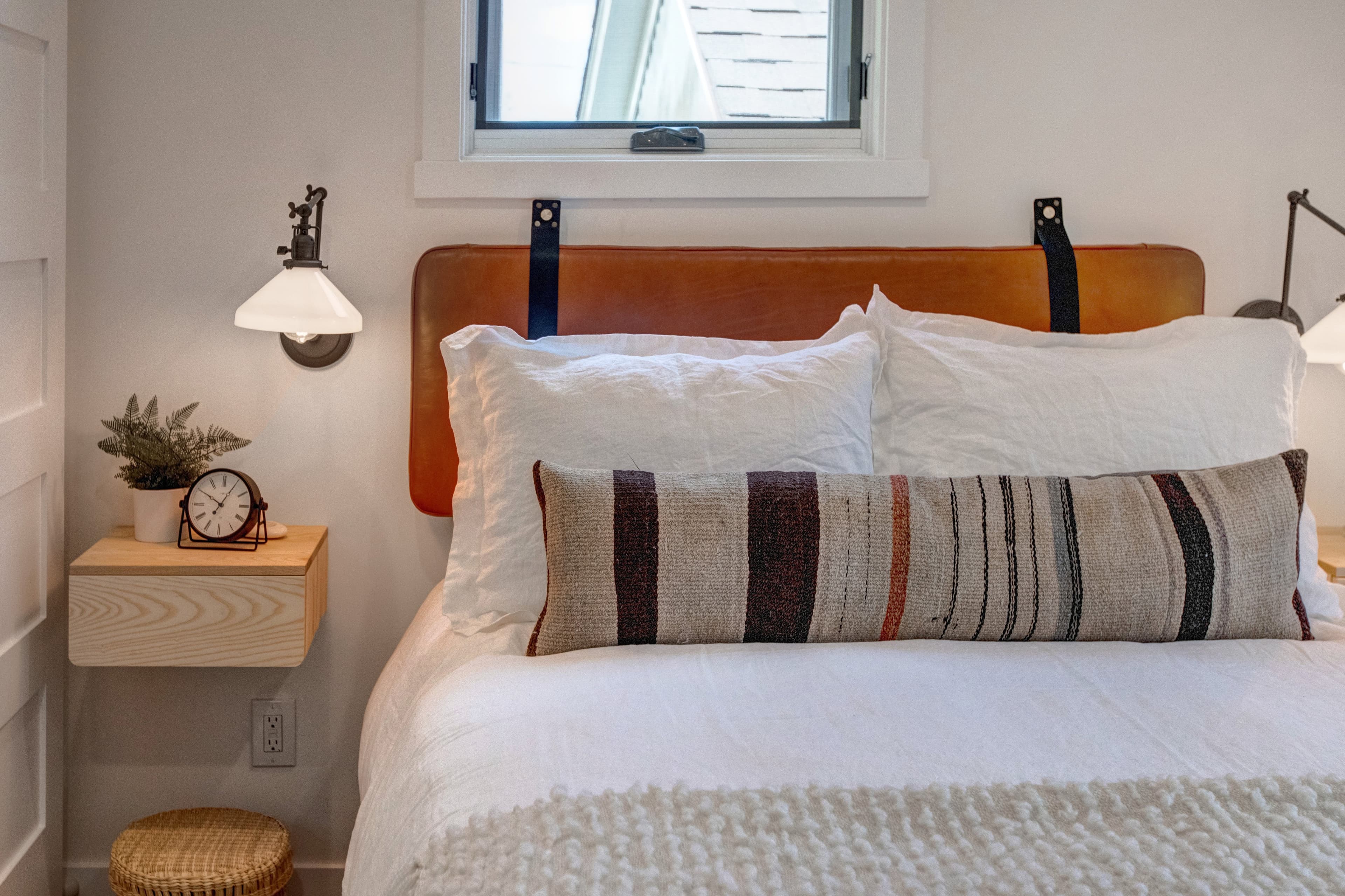 Lofted bedroom in detached guest suite, with a queen bed next to standalone bathtub.
