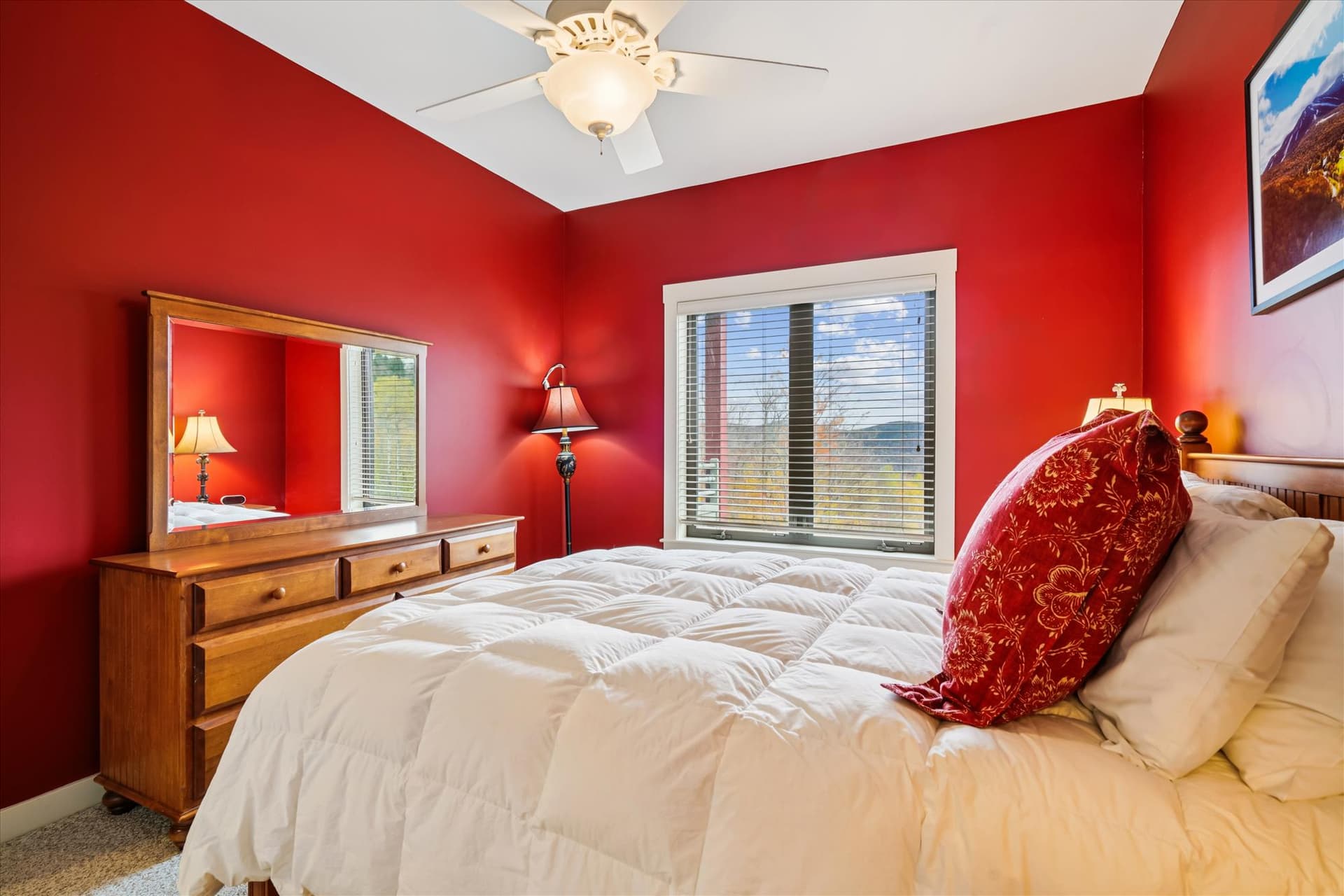 Wake up to soft mountain light and settle into a restful queen bed surrounded by warm red tones and wood accents. The private bath makes this space ideal for couples or friends sharing the adventure.