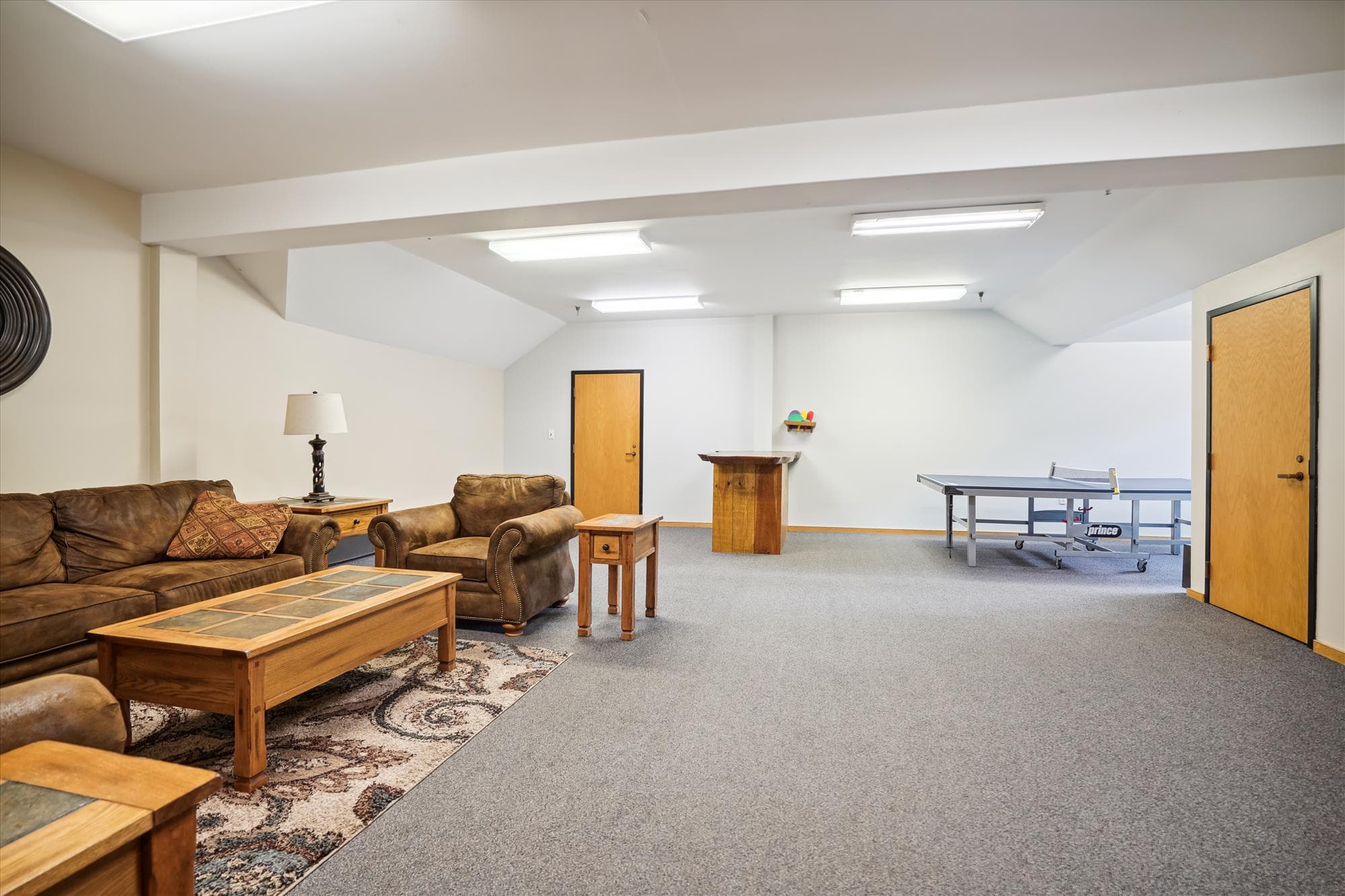 Spacious recreation room at the Sports Center featuring seating areas and a ping pong table.