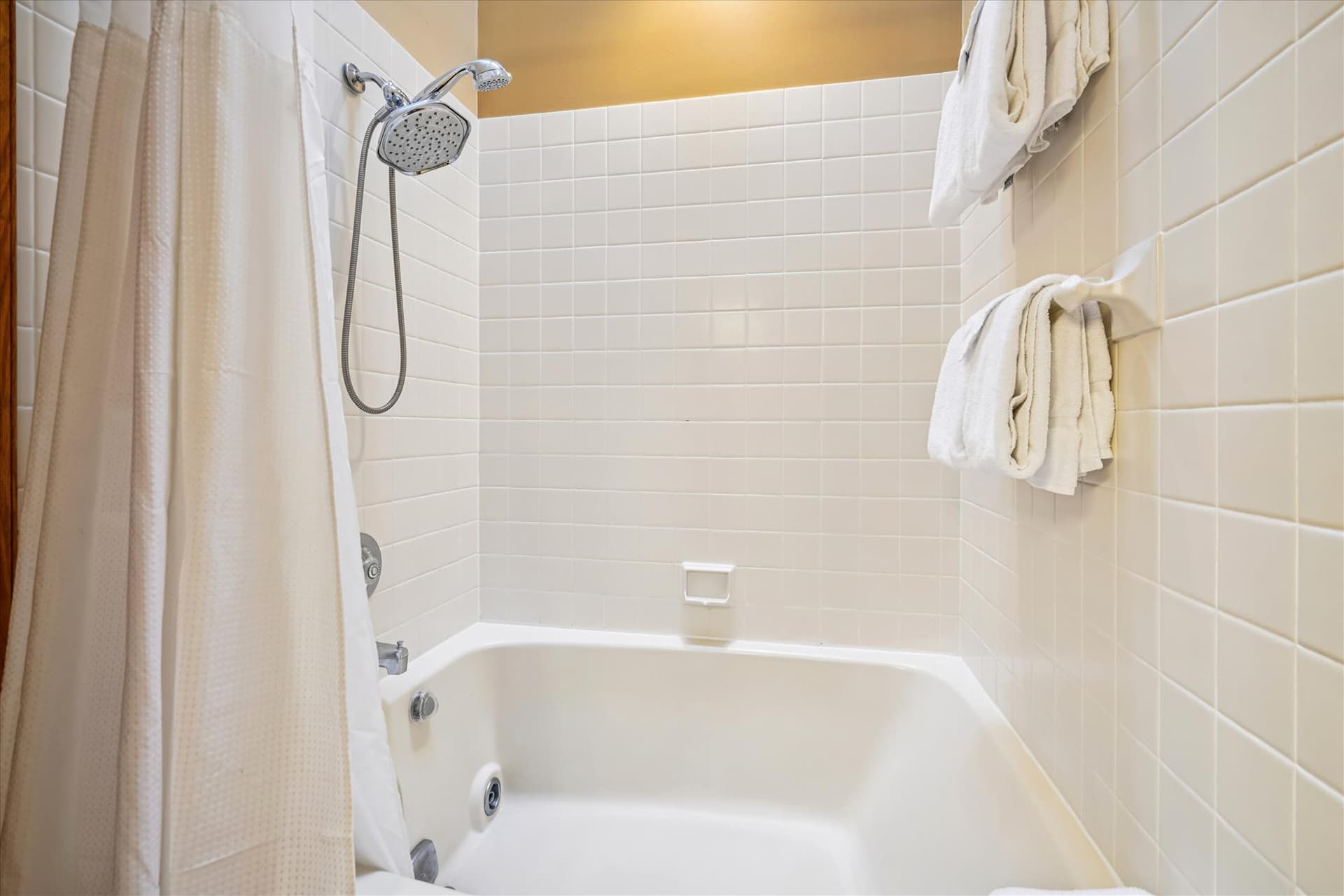 Full bathroom featuring a tub and shower combination with fresh towels provided.