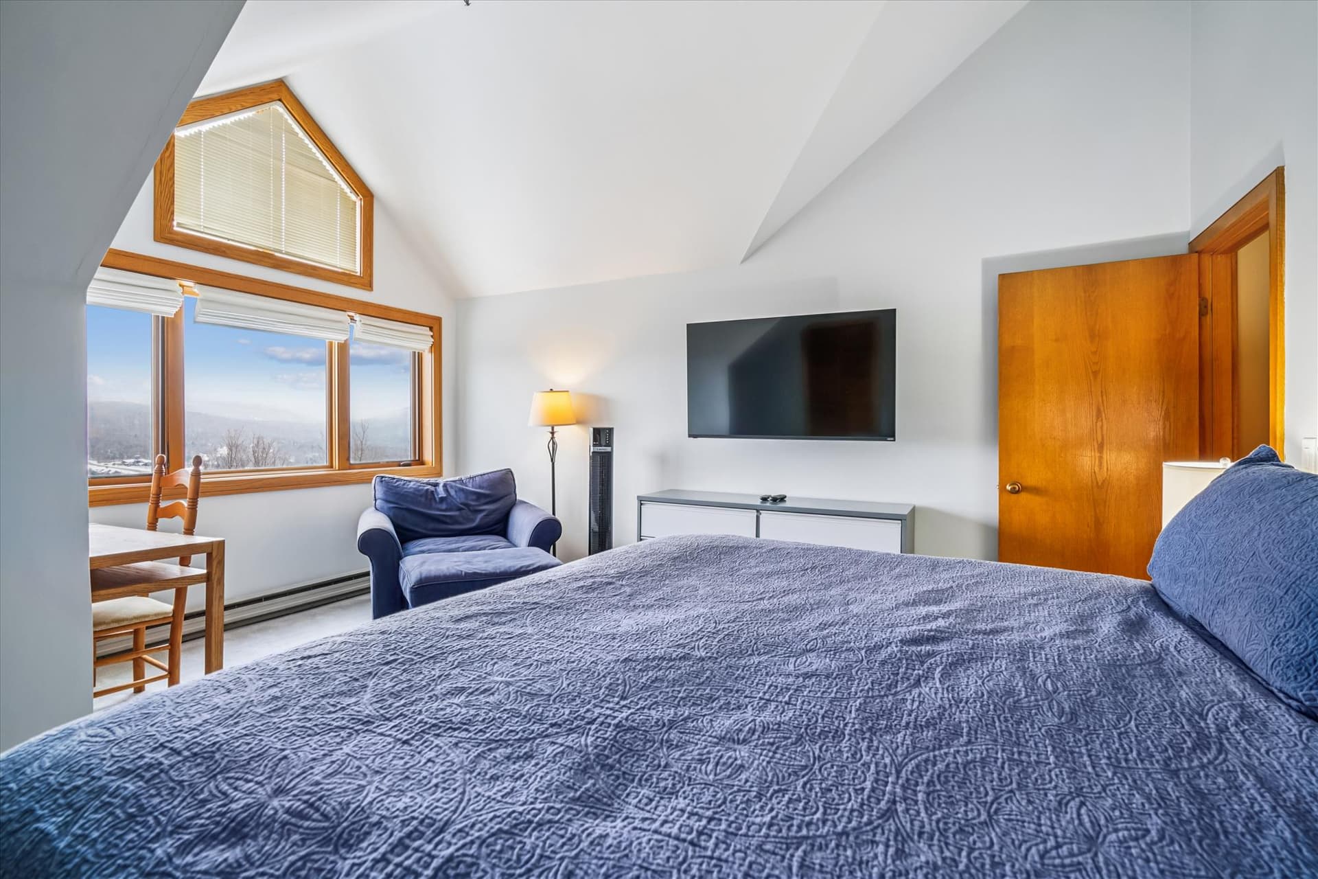 Relax in the upstairs king bedroom while enjoying scenic views through the large windows.