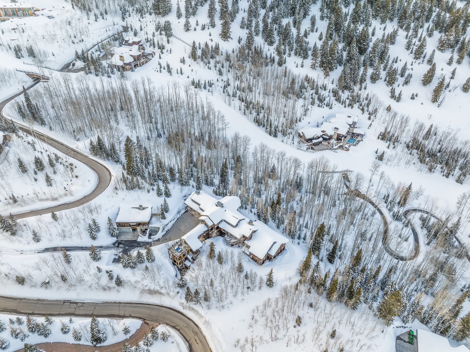 An aerial view of Talus Ridge, showing winding roads around it tracing their way through the snow.