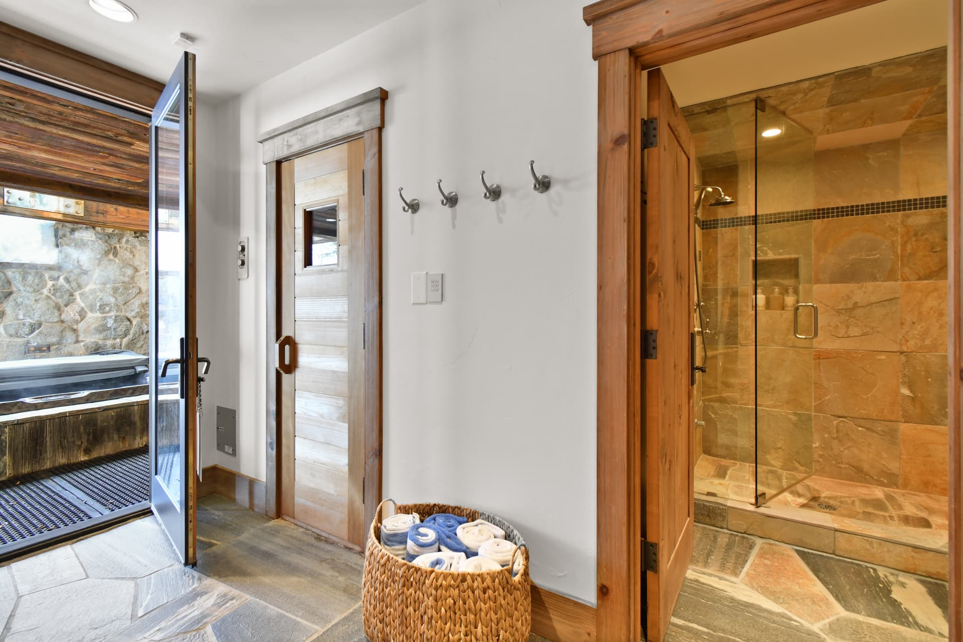 A basket of towels sits next to the doors to the sauna, private bathroom, and private shower.