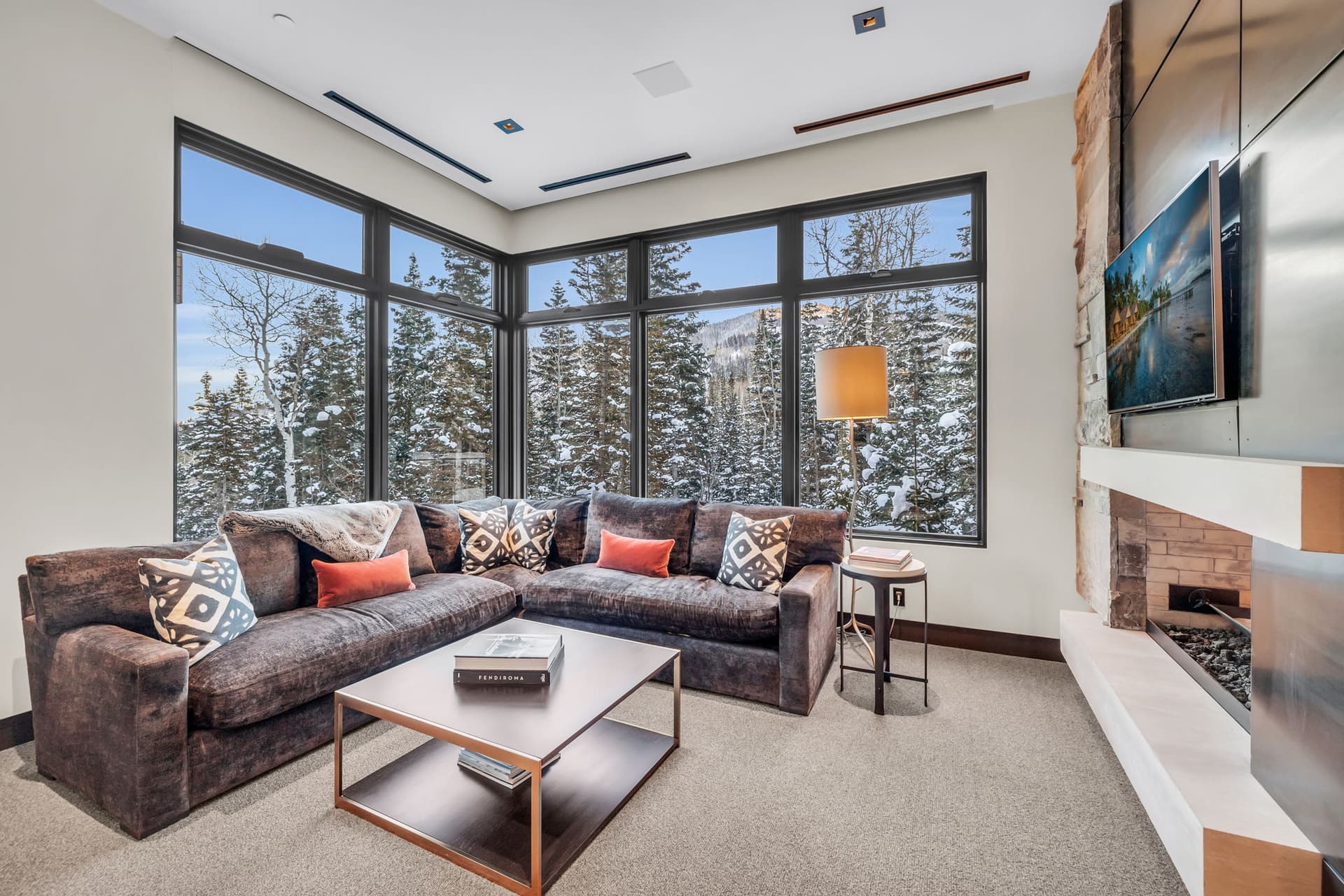 A cozy lounge with panoramic windows and a fireplace.