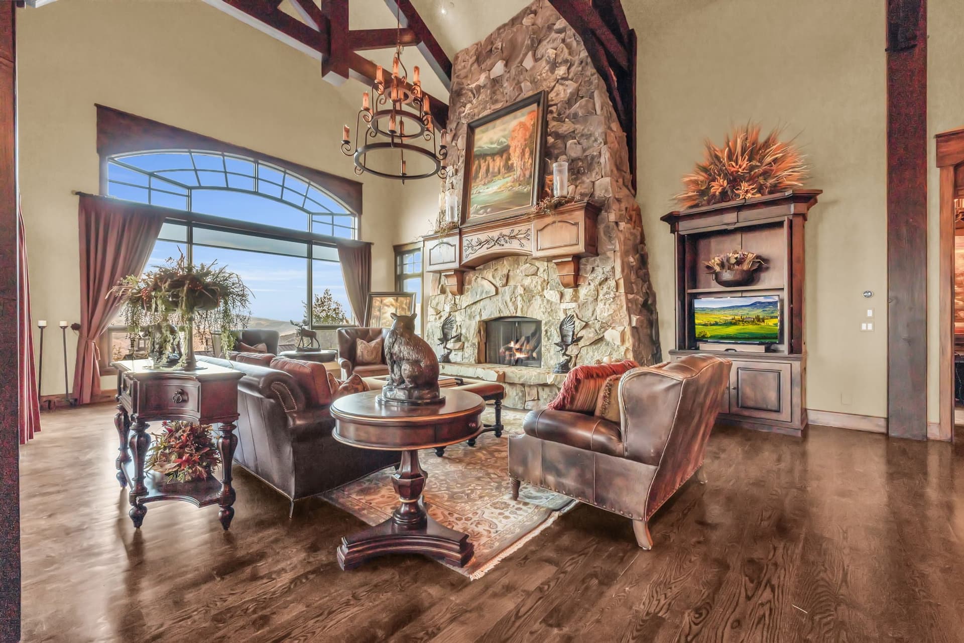Grand fireplace with paintings and leather couches.