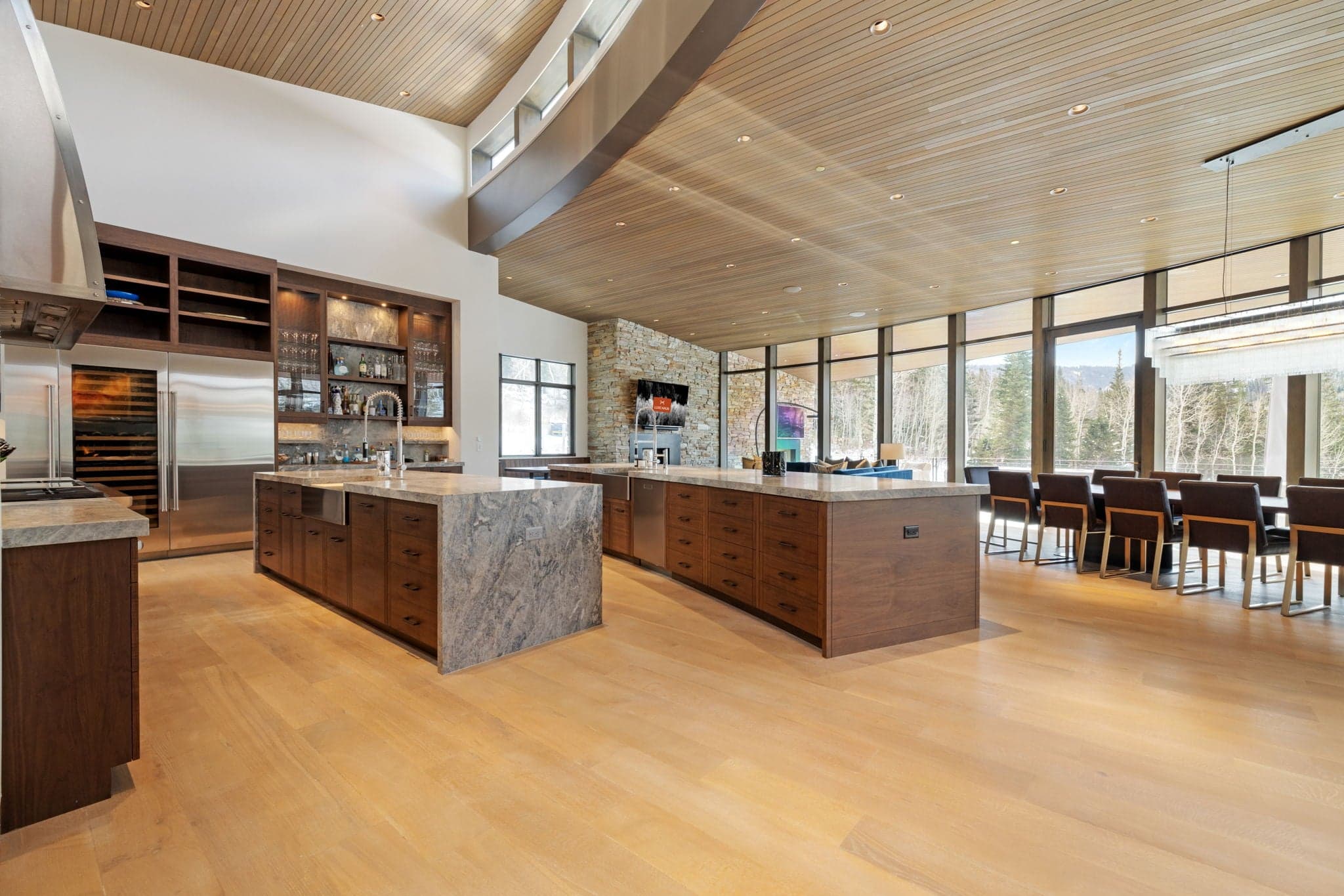 A kitchen view with an island and a refrigerator.