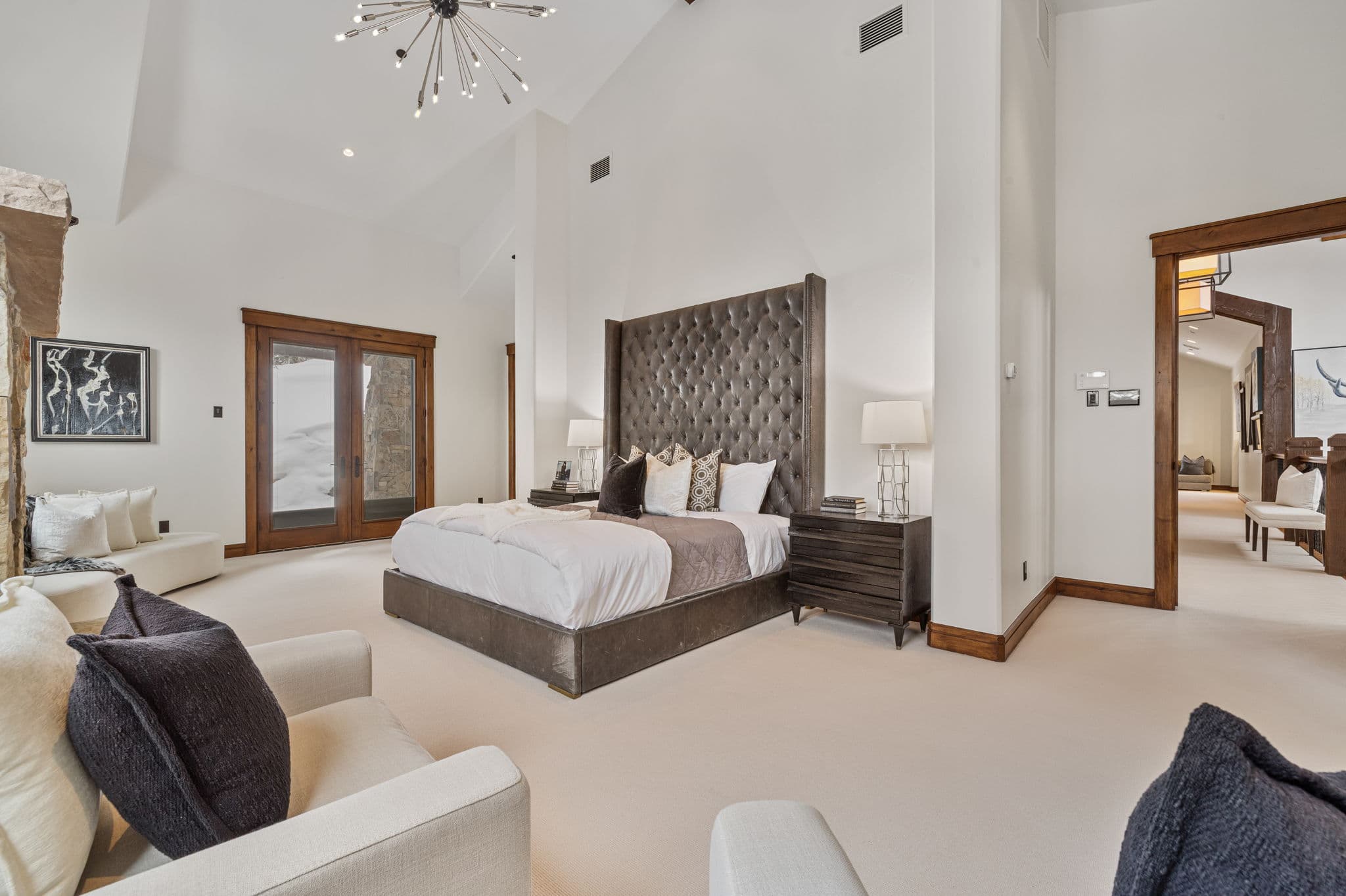 the master bedroom facing the bed there is a large chandelier overhead