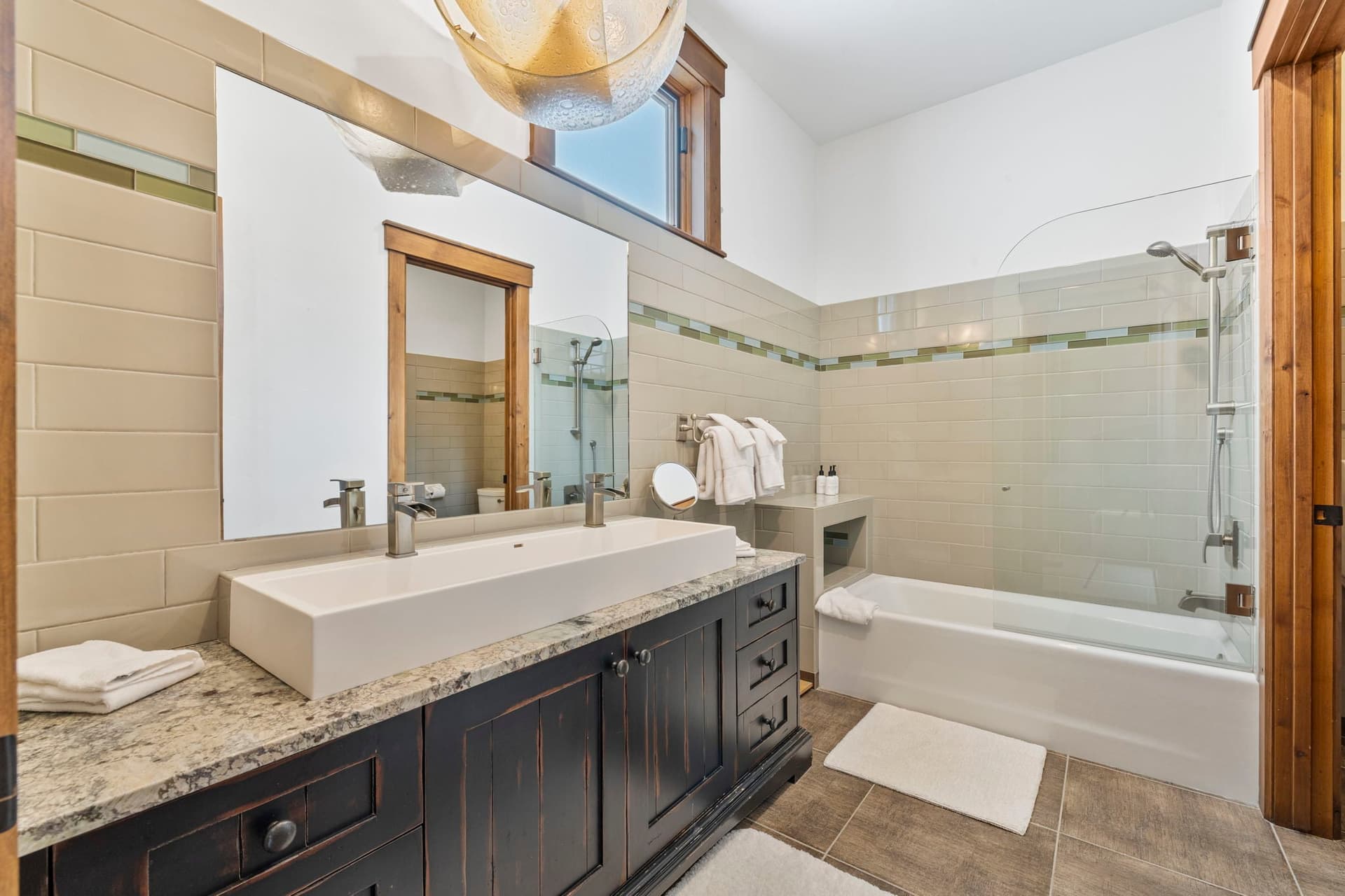guest en suite bathroom with large sink and double faucets and a tub and shower