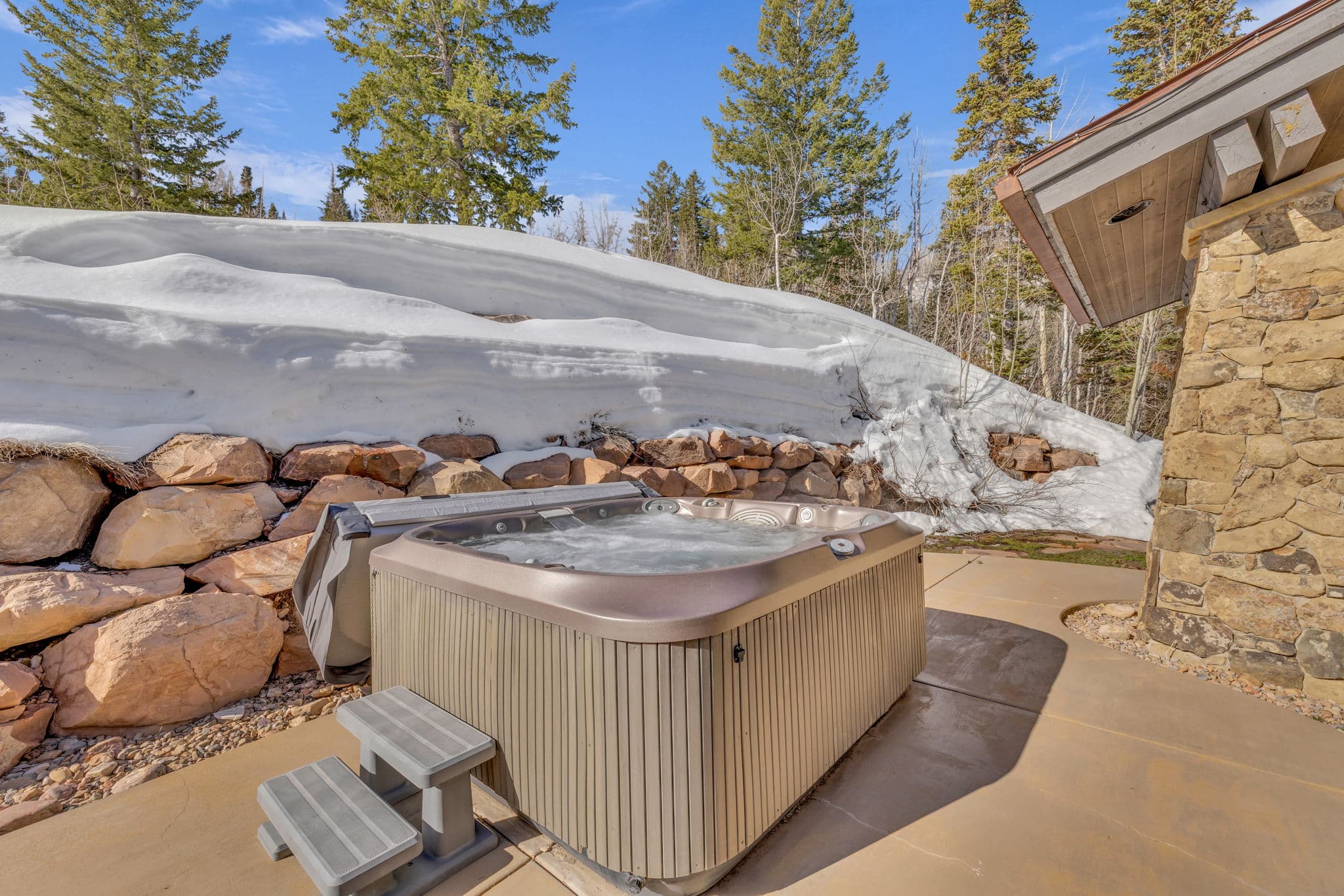 view of hot tub with snow and trees around it