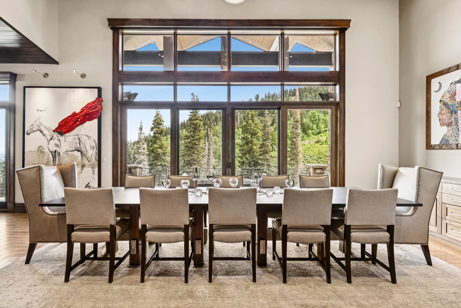 long dining room table with striking custom artwork on the walls and large views overlooking the mountains