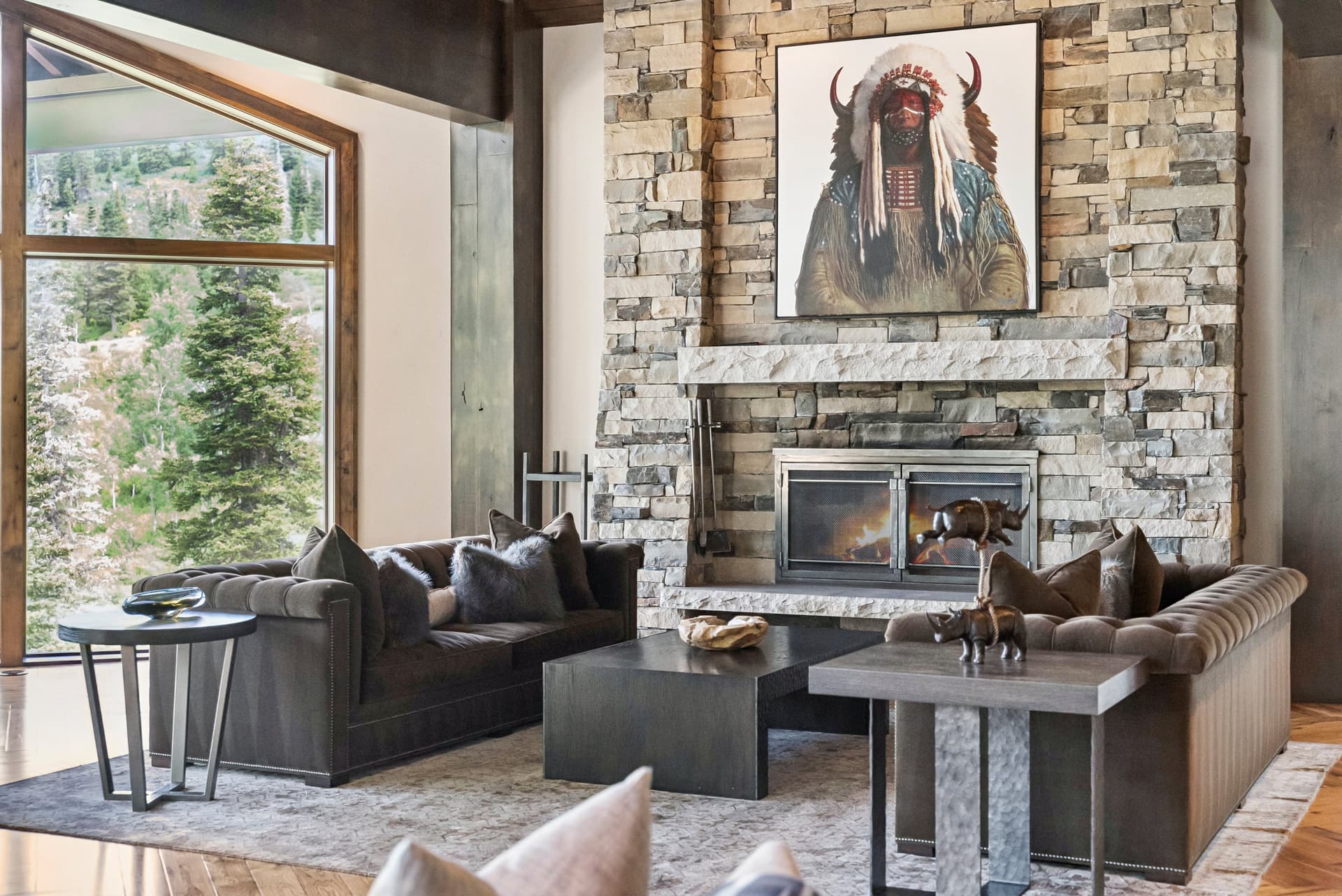 a stunning seating area with overstuffed couches, a large fireplace and stunning artwork above the mantle