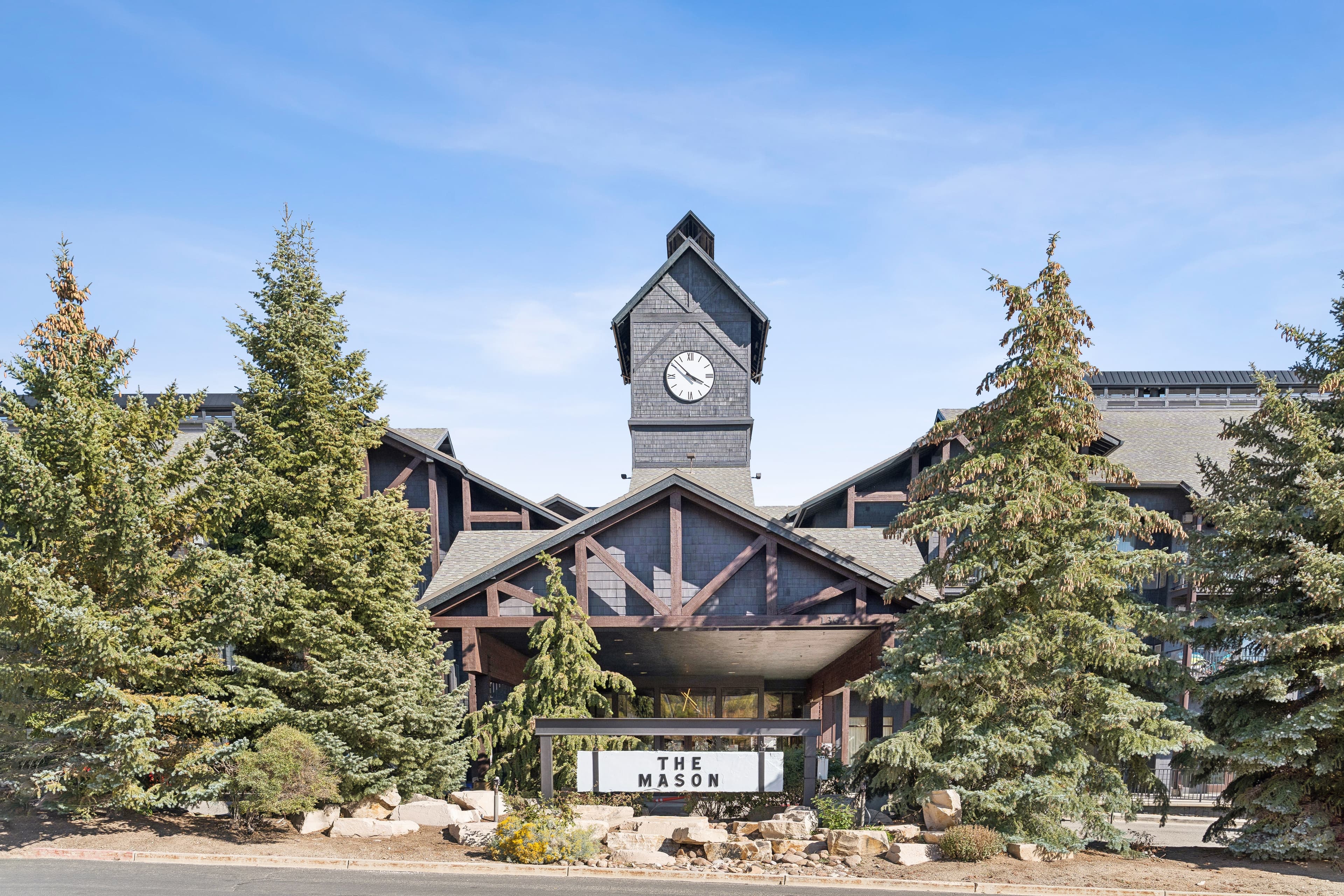 Exterior view of a Park City condo complex The Mason with alpine architecture and a signature clocktower.